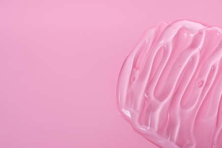 Gel cosmetic smears for skin care on a pink background, cream, peeling, milk, lotion, drops texture. Close up with copy space.の写真素材