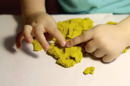 A child plays with kinetic sand. sensory development. Motor development. Childrens gamesの写真素材