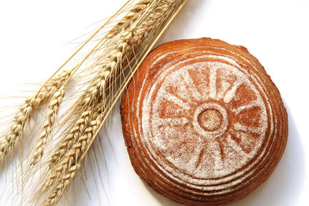 Round yeast-free rye bread and ears of rye on a white isolated background. top viewの写真素材
