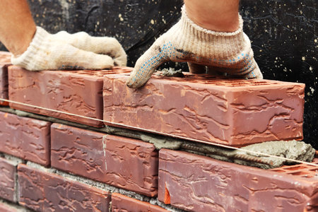 Construction of a brick wall. bricklaying. A worker builds a brick wallの写真素材