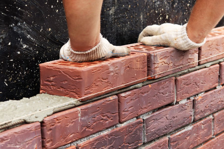 Construction of a brick wall. bricklaying. A worker builds a brick wall