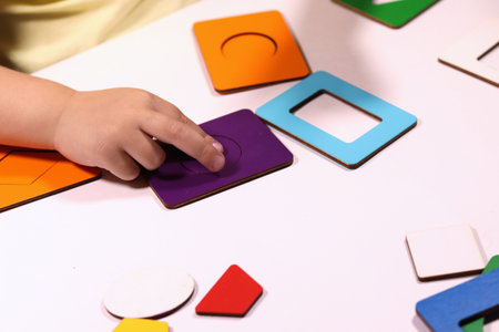 The child plays with colorful toy blocks. eco wooden toys. Little smart child playing natural toys. games for early development. Toy in childrens hands close-up. selective focusの写真素材