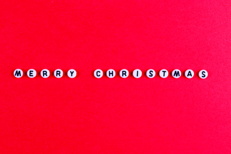 Lettering WITH MERRY CHRISTMAS on a red paper background. New Years card, bannerの写真素材