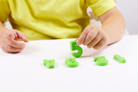 The child shows the number 5. Early development, playing with numbers, learning to countの写真素材