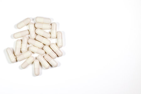 White capsule pills on a white background. Epidemic, painkillers, healthcare, medical pills and drug abuse concept. flat lay. Place for text.の写真素材