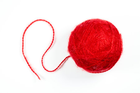 A ball of red woolen threads on a white background. High quality photo.の写真素材