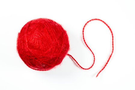 A ball of red woolen threads on a white background. High quality photo.の写真素材