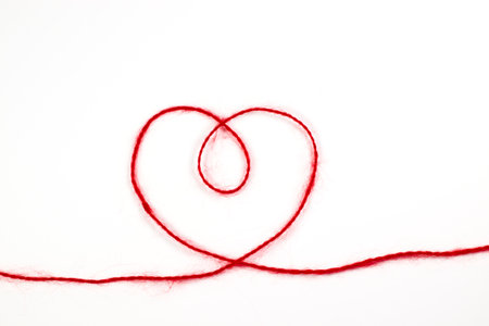 Heart from a red woolen thread on a white isolated backgroundの写真素材