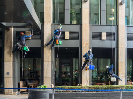 Moscow, Russia â€“ September 18 2021: Group of industrial mountaineering workers hang over...