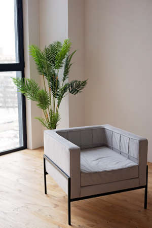 Stylish modern gray armchair in the interior. Soft selective focus.