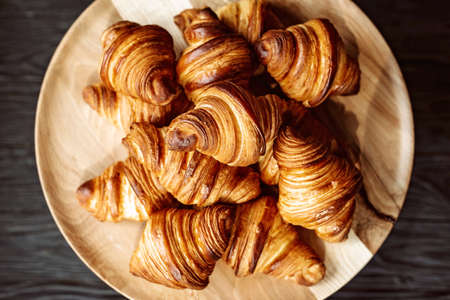 Fresh baked croissants. Warm fragrant butter croissants and rolls on a wooden stand. French and...