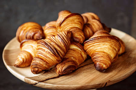 Fresh baked croissants. Warm fragrant butter croissants and rolls on a wooden stand. French and...