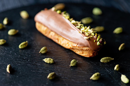 French dessert eclairs or profiteroles with milk chocolate glaze flavored with cardamom and...