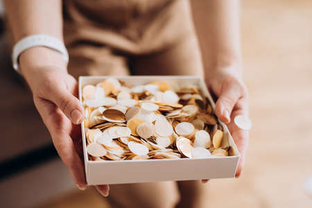 Beautiful blonde woman with a gift box in her hands with push-pop confetti. Gift for birthday, womens day, mothers day. Soft selective focus, defocus, art noise.の写真素材