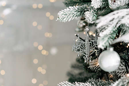 Christmas minimal background, a Christmas tree decorated with balls on a background of blurry bokeh lights. Baner, holiday card, mockup. New Year 2021. Soft selective focus, copy space.の写真素材