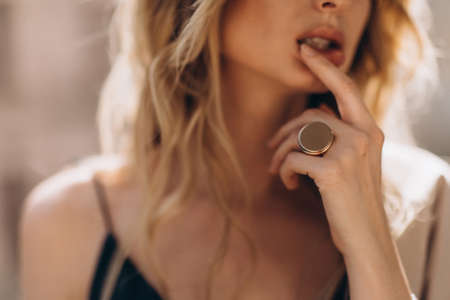 Defocused art portrait of a beautiful blonde woman through the glass in beige tinting. Out of focus