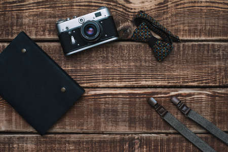 father's day with men's accessories bow tie, wallet, retro camera, suspenders and notepad and leather shoes on a wooden background. Copy space. Flat lay.の写真素材