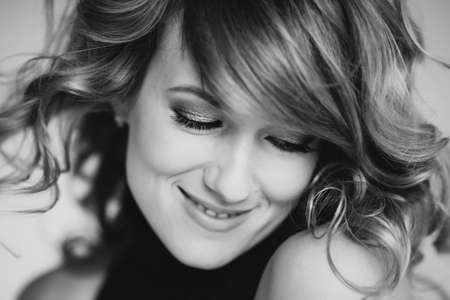 Portrait of a beautiful girl 36 years old with curly hair and an open playful smile. Soft selective...