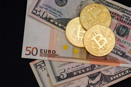 Bitcoin coins on dollar and euro bills. Virtual cryptocurrency purchase concept. Black background....