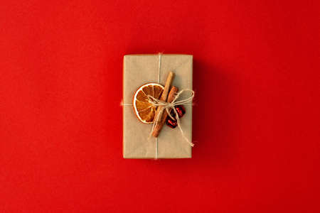 Christmas minimal composition. Gift craft box, decoration on a red background. Flat lay, top view,...