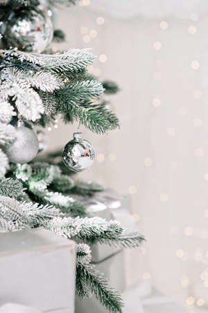 Christmas minimal background, a Christmas tree decorated with balls on a background of blurry bokeh lights. Baner, holiday card, mockup. New Year 2021. Soft selective focus, copy space.の写真素材