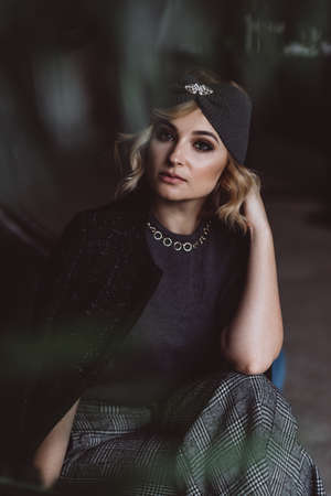 Portrait of a beautiful stylish blonde woman in a knitted headband in a loft interior. Soft selective focus, defocus. No retouching.の写真素材