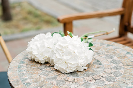 Lonely romantic bouquet of white hydrangea flowers on a stone table. Soft selective focus.の写真素材