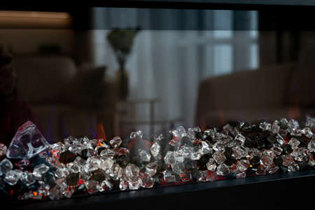 Modern electric fireplace with crystal stones in a designer interior, close-up. Soft selective focus, art noiseの写真素材