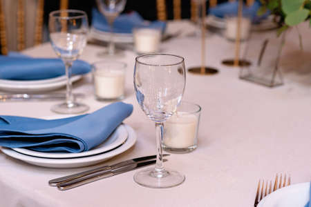 Festive wedding, table setting with blue linen napkins, candles. Wedding decorations. Restaurant...