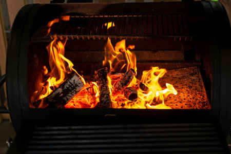 Hot empty charcoal barbecue grill with bright flame. Soft selective focus.