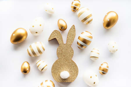 easter bunny and golden eggs isolated on white background. Happy Easter minimal concept, greeting...