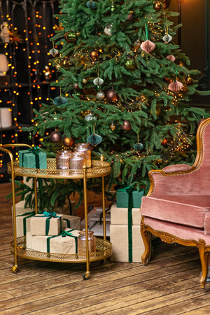 Christmas home room with fir tree and festive bokeh lighting, blurred holiday background, gift boxes and new year decor. Soft selective focus.の写真素材