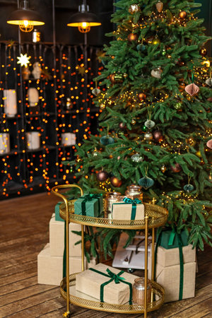 Christmas home room with fir tree and festive bokeh lighting, blurred holiday background, gift boxes and new year decor. Soft selective focus.の写真素材