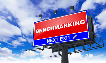 Benchmarking Inscription on Red Billboard on Sky Background の写真素材