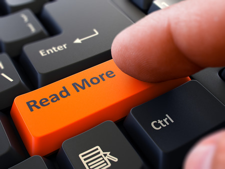 Person Click on Orange Keyboard Button with Text Read More. Selective Focus. Closeup View.の写真素材