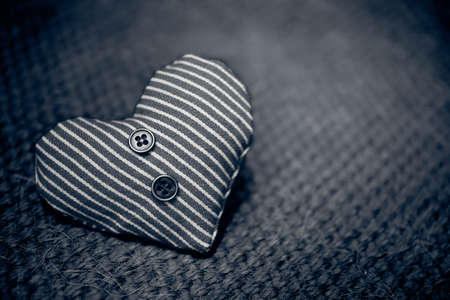 one heart textile with buttons on a dark backgroundの写真素材