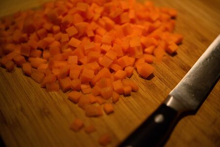 carrots, diced with a knife on a wooden cutting boardの写真素材