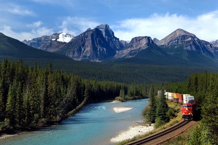 Freight train moving along Bow river in Canadian Rockiesの写真素材