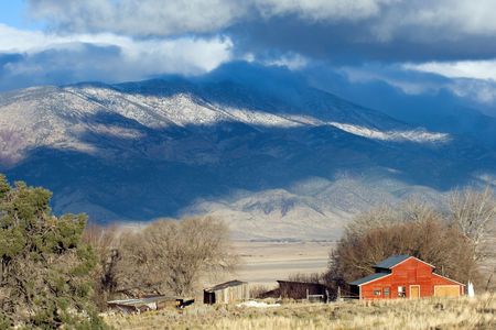 Red ranch house in Nevada state with mountain range on backgroundの写真素材