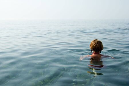 Girl swimming in crystal clear water of Black Sea, Ukraineの写真素材