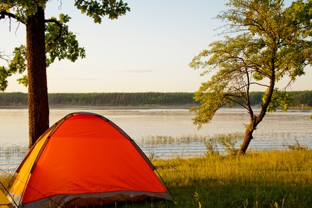 Bright tent by the picturesque lake around sunsetの写真素材