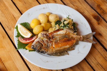 A traditional plate of grilled fish and sides in Croatian restaurantの写真素材