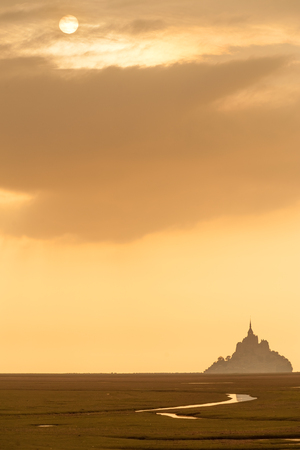 Silhouette of famous Mont Saint Michel on Normandy coast at sunset, Franceの写真素材