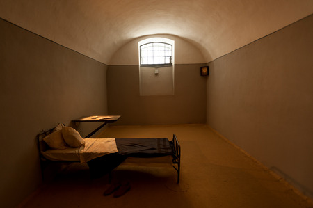 Dark prison cell with antique furniture inside historical fortressのeditorial素材