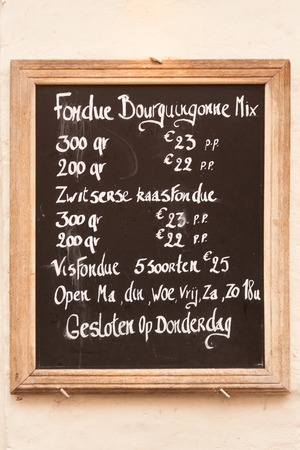 Menu board with local fondue specialities on Bruges street, Belgiumの写真素材