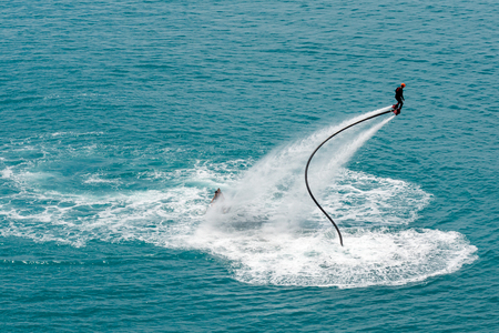 Flyboarding session in the aquamarine waters of sea resortの写真素材