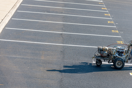 Worker with a striping mashing painting fresh lines in development parking lot, USAの写真素材