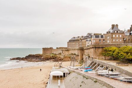Sandy beach in high tide and city walls of famous corsair fortress Saint-Malo, Brittany, Franceのeditorial素材