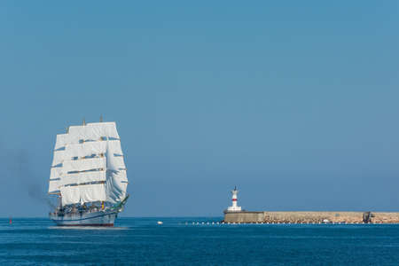 Beautiful three mast tall ship sailing pastFort Constantin lighthouse at the entrance to Sevastopol Bay, Crimeaの写真素材