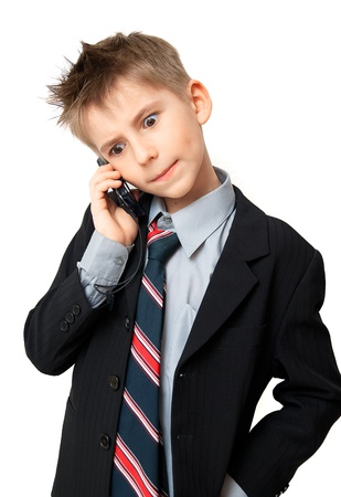 Cute  Boy in Suit talking on a cell phone over a white backgroundの写真素材